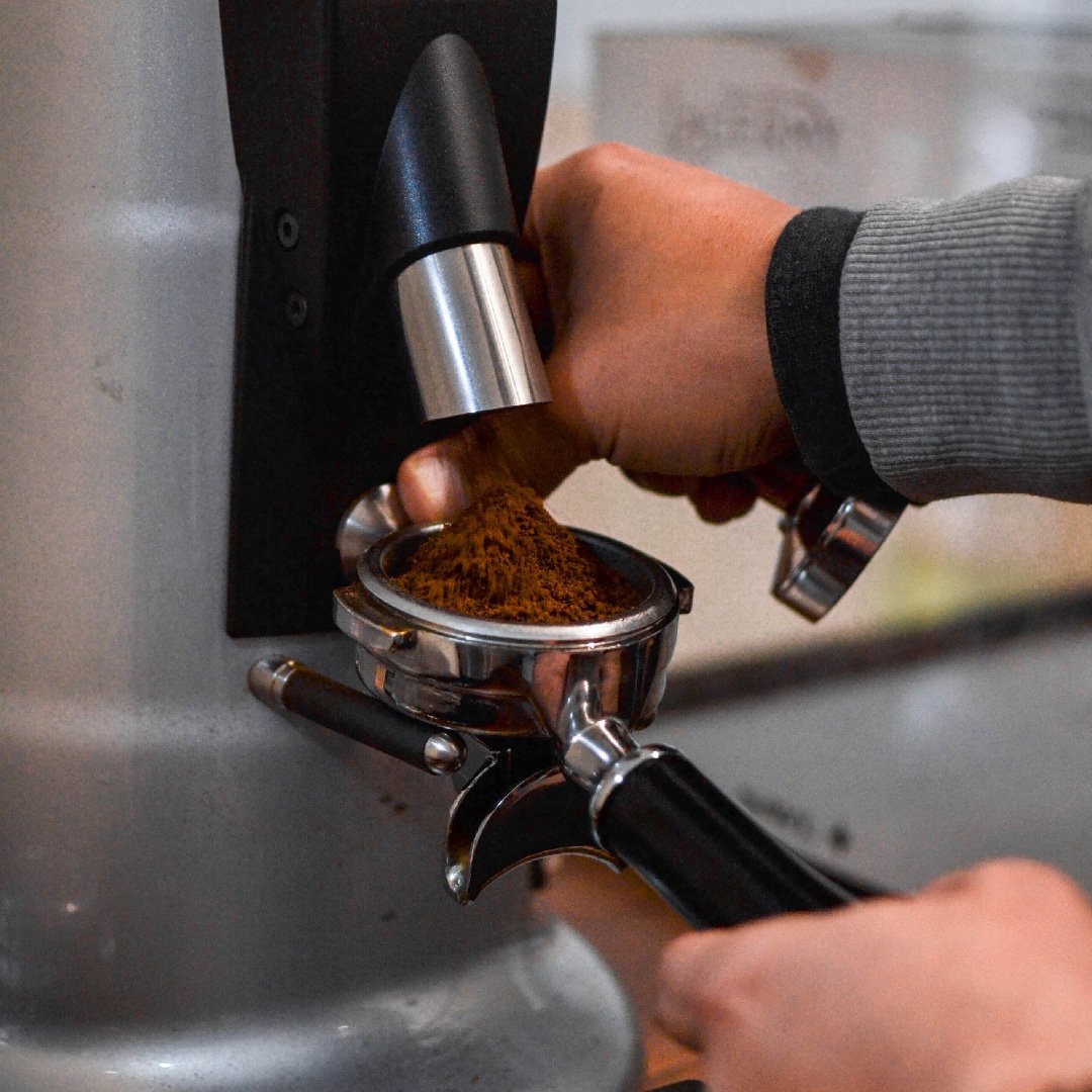 Café de especialidad en grano, báscula, molino y kettle en una escena técnica