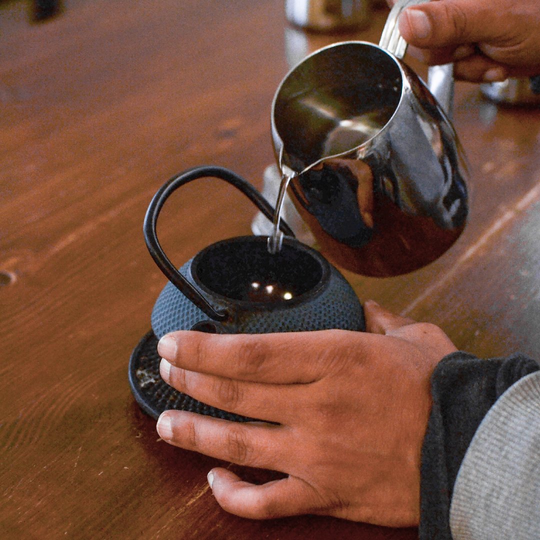 Agua vertiéndose sobre té en hoja con control de temperatura
