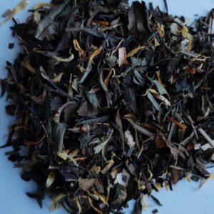 Hojas de té en seco en composición editorial sobre fondo limpio